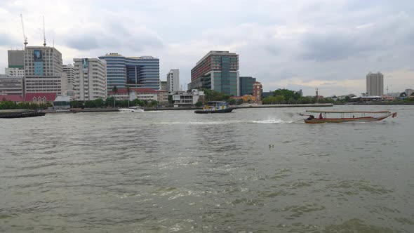 Long-Tail Boat Moving Down on Chao Phraya River in Bangkok City at Summer Day