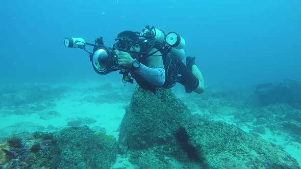 A video of an underwater cameraman taking photos of marine life in the ocean with underwater equipme