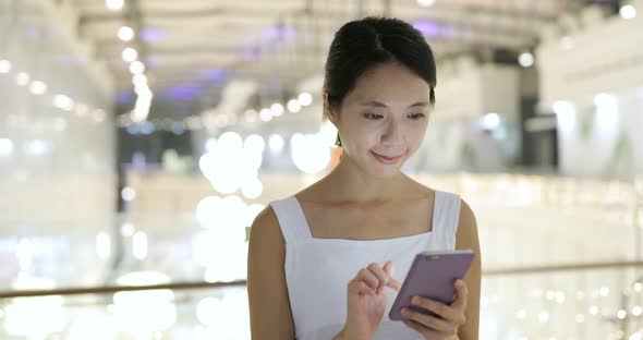 Woman using cellphone inside shopping mall