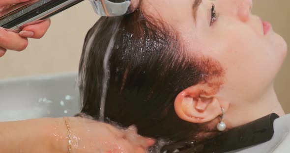 Hairdresser Washes Young Woman Hair Closeup
