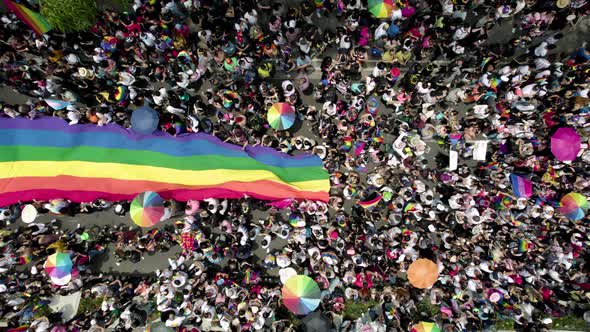 cenital drone shot of a crowd waving the gay pride flag at the pride parade in mexico city