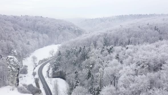 Aerial View of a Fairy Winter Landscape a Car Rides Along a Road in a Forest Covered with Snow in