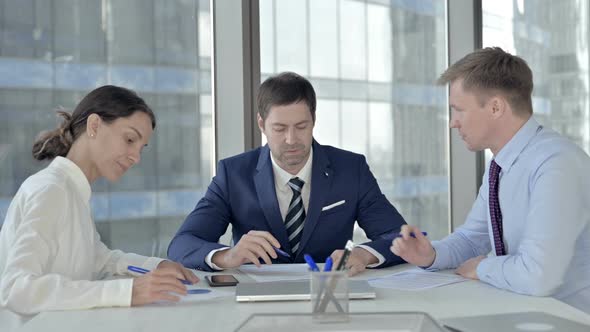 Middle Aged Businessman Having Meeting with His Assistants in Boardroom