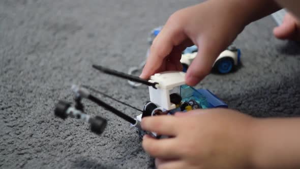 A small child plays a construction set. Construction of cubes.