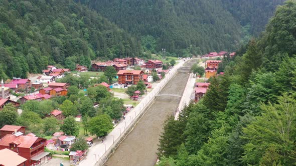 aerial drone view of a mountain village near a river and forest on a sunny summer day in Uzungol Tra