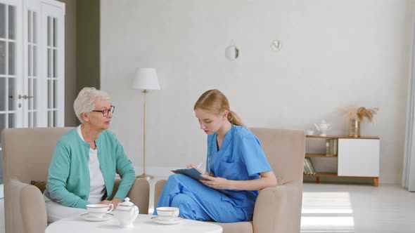 Senior lady patient with glasses talks to attentive young nurse