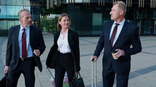 Confident Professionals Pulling Suitcase in the Modern Business Centre, Traveling on a Business Trip