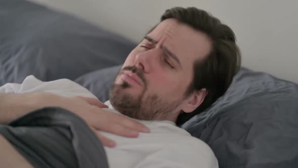 Young Man Coughing While Sleeping in Bed