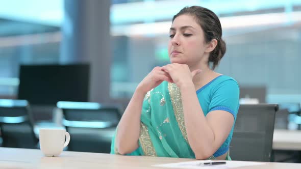 Young Indian Woman Thinking while Sitting at Work