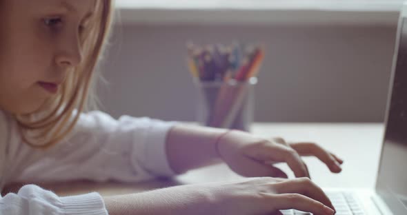 Close-up Serious Focused Little 8 Years Old School Girl Looking in Laptop Screen Typing on Keyboard