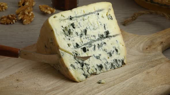 Cutting a piece of traditional French Bleu d'Auvergne cheese 