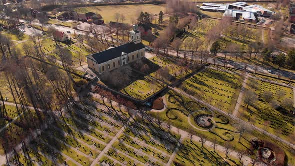 Drone flying towards church passing graves