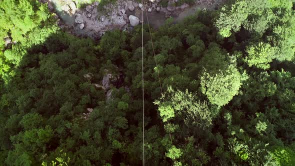 Aerial view of a person canopying over the forest in zip-line at Slovenia.