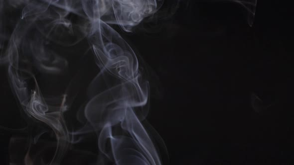 Slow motion of white abstract cigarette smoke on black background