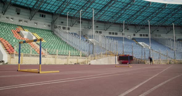 Sportsman Doing Hurdling on Arena