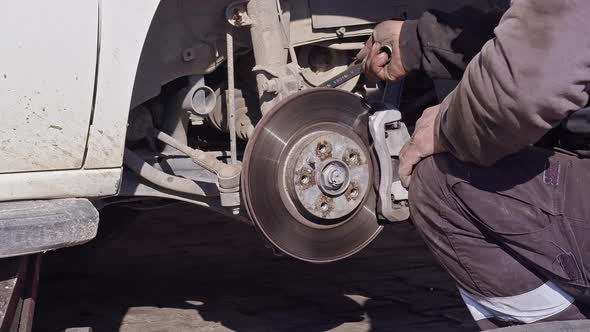 Mechanic Repairing The Brake Disc Of The Car