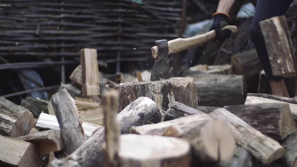 Man Chops Wood Outdoors in Slow Motion. Man's Hands Working with Ax. A Man Woodcutter Chops Tree