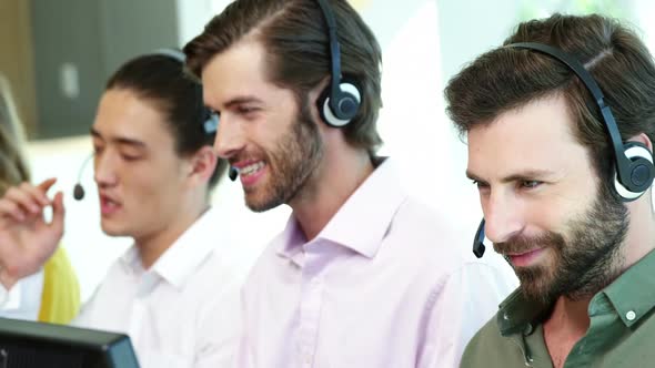 Team of customer service executives working at desk