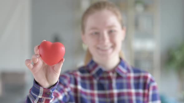 Rear View of Young Woman Showing Heart Shaped Toy