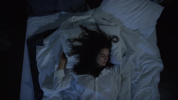 Young Woman in Mens Shirt Stretching in Bed while Sleeping at Night