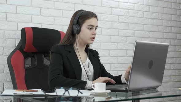 Business girl in headphones at the computer.