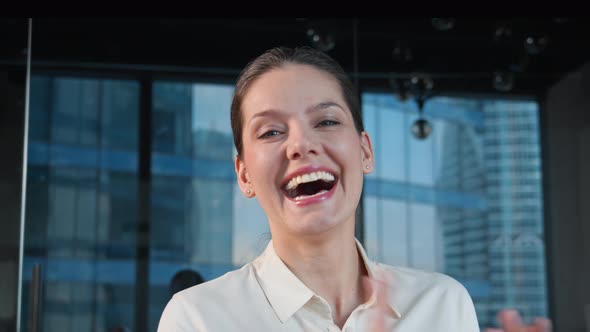 Young woman discussing via video call in the office. Young woman cheering while chatting