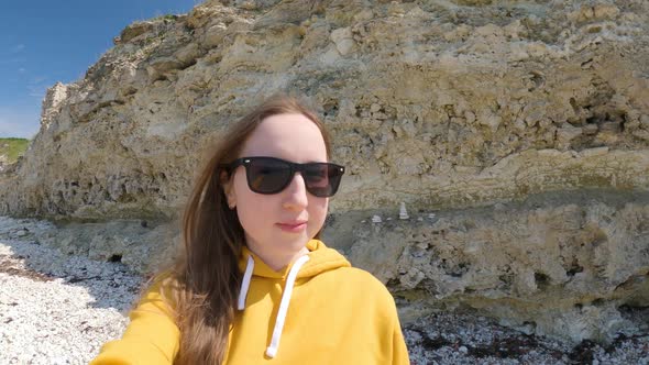 Young Woman in Sunglasses Makes a Selfie in Nature