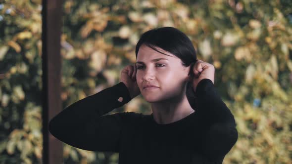 Young woman doing warm-up on terrace. warm-up for the ears