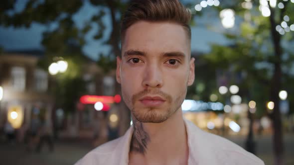 Portrait of Stylish Guy with Tattoo and Trendy Hairstyle in City Street at Night