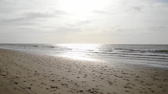 Sea Waves And Sandy Beach In Brouwersdam, Netherlands - aerial pullback