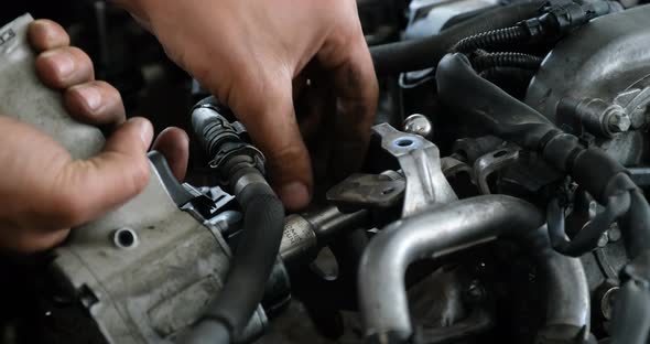 Car Mechanic Tightens Part Of The Car Engine