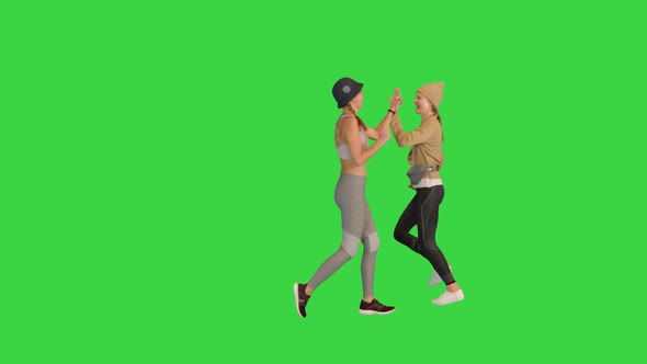 Fit Young Women Running and Giving High Five to Each Other on a Green Screen Chroma Key