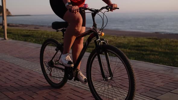 Young Woman in Sportswear Protective Helmet Cycling and Pedaling in Park