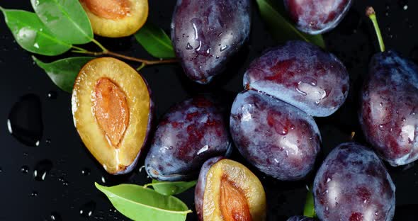 Whole and Slices Plum with Leaves Slowly Rotate. 