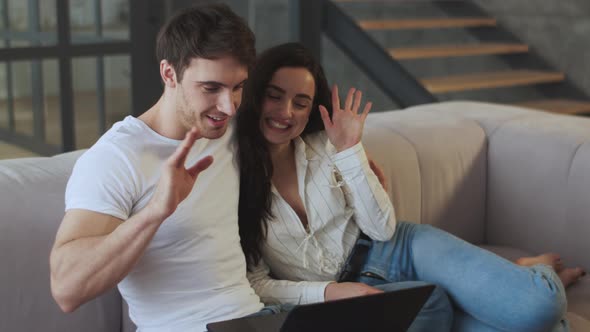 Happy Couple Chatting on Skype at Laptop Computer at Home Together