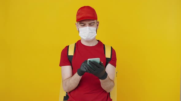 Male Courier Wearing Protective Face Mask Using Smartphone and Showing Device with Green Chroma Key