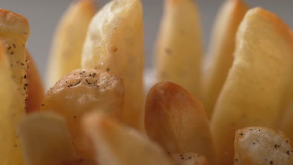 Adding black pepper on french fries. Slow Motion.