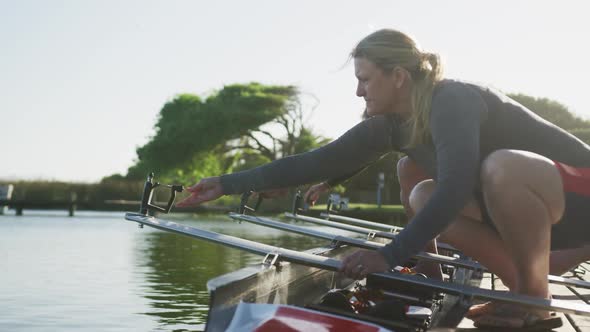 Senior caucasian woman preparing rowing boat in a river