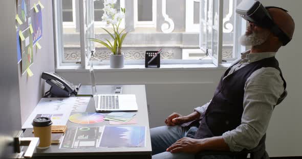 Businessman using virtual reality headset on desk