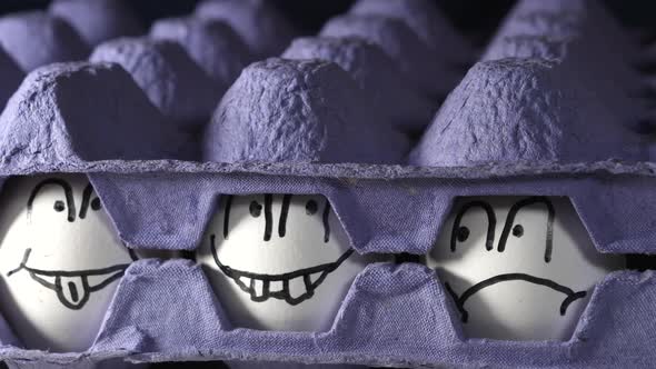 Two Blue Egg Trays with the Drawn Faces Eggs on the Center