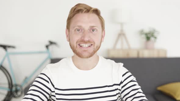 Happy Young Man Talking on Video Call From Living Room at Home alt