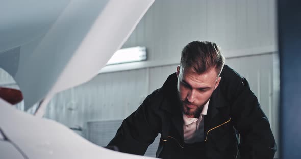 Charismatic Mechanic Guy Fixing the Crashed Car in