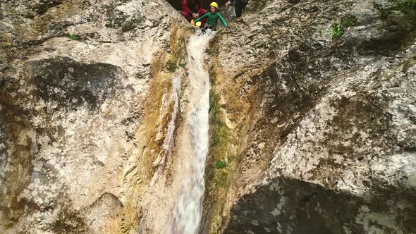 Aerial view of a kid throwing himself through a sliding rock at Soca river.