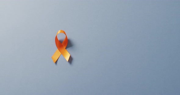 Video of orange kidney cancer or leukemia ribbon on pale blue background