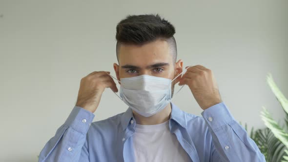 Portrait of A Young European Man Wearing A Virus Mask at Home in A Bright Room during a Pandemic