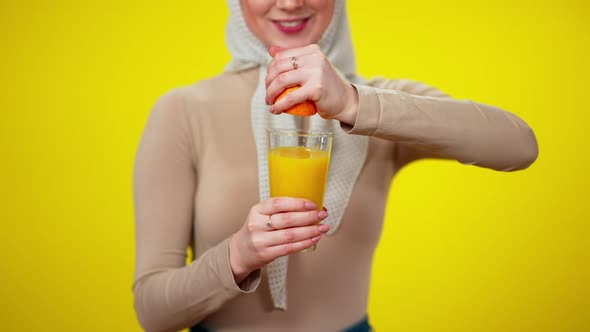 Unrecognizable Slim Woman Squeezing Orange in Glass in Slow Motion