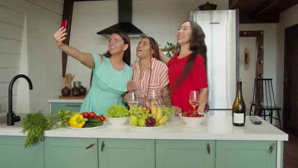 Mixed Race Women Dancing in Kitchen When Friend Calling on Smartphone