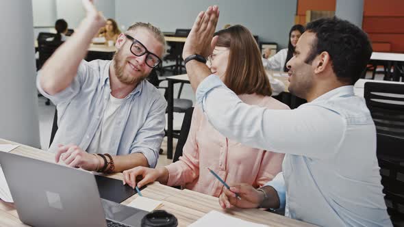 Young Multiracial Diverse Colleagues Rejoicing That They Have Developed New Business Plan Sitting at