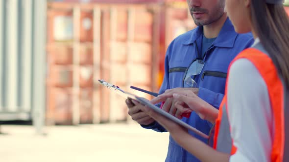 Two engineer male and female worker dockers in checking examine discussion