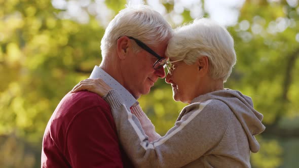 Senior Married Caucasian Couple Being Affectionate and Embracing Each Other in an Autumn Park